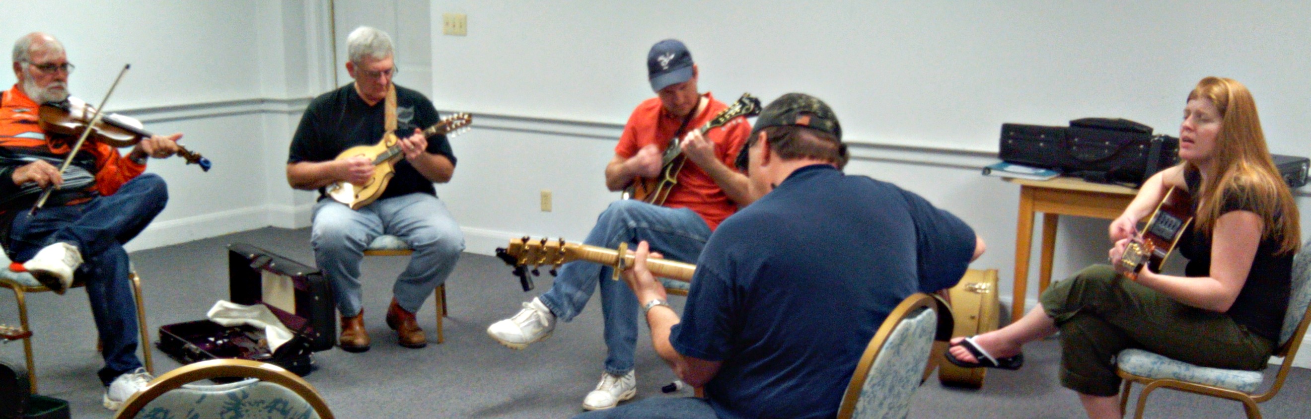 An informal jam session. People playing instruments in a circle